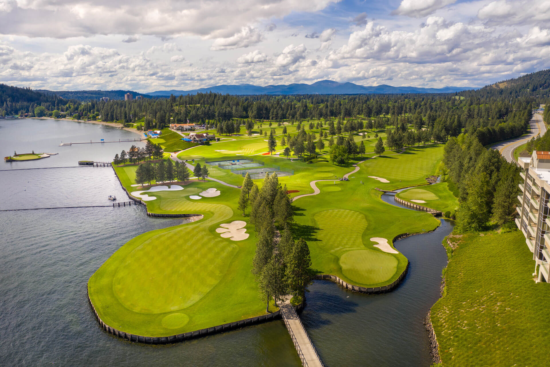 Aerial view of golf course surrounded by lake